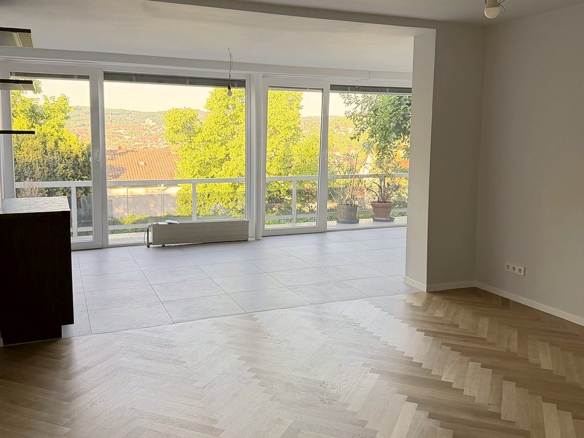 Heller Ess- und Wohnbereich mit bodentiefen Fenstern und Blick über Stuttgart